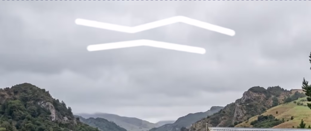 Two white brush strokes across a cloudy sky above hills