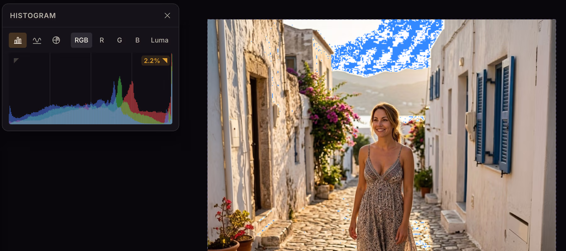 The Histogram card beside a photo of a whitewashed street at sunset, with the clipped highlights in the sky flashing blue