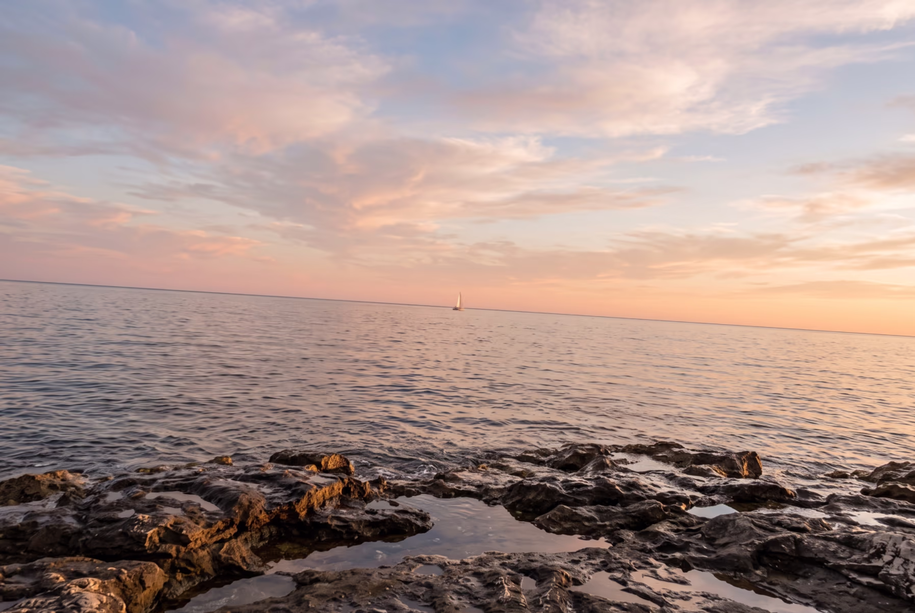 A sunset over the sea shot with the camera tilted: the horizon runs downhill from left to right